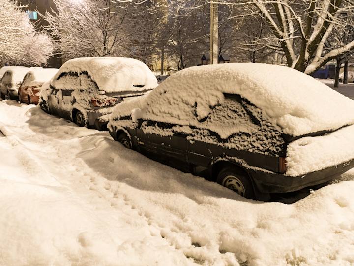 Biler i siden af vej med meget sne på sig