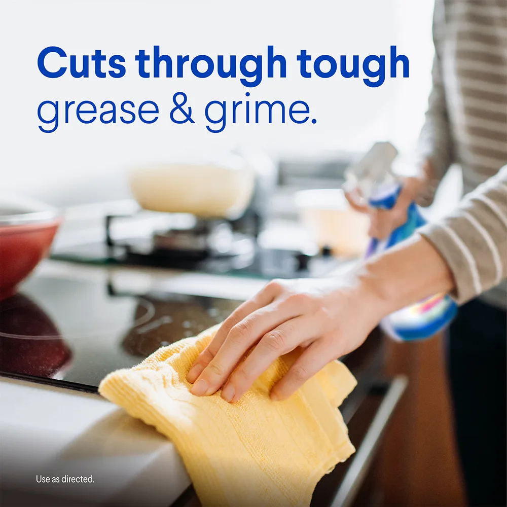 Person wiping a stovetop with the words Cuts through tough grease & grime.