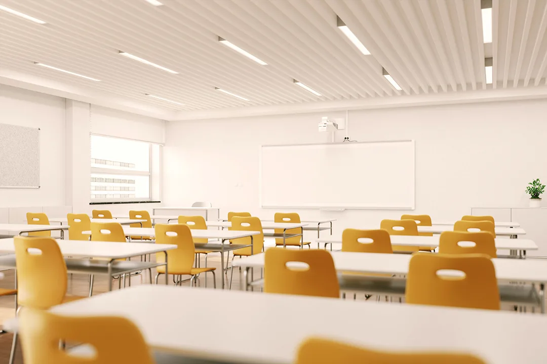 Modern classroom with yellow chairs, white desks, whiteboard, projector, and slatted ceiling with natural light.