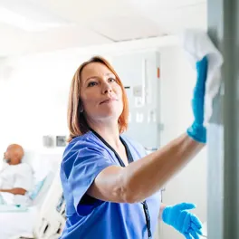 enfermera limpiando superficies en un hospital
