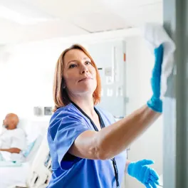 nurse wiping surfaces in a hospital