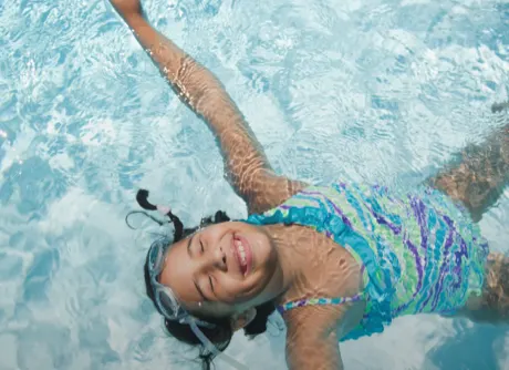 girl floating in swimming pool