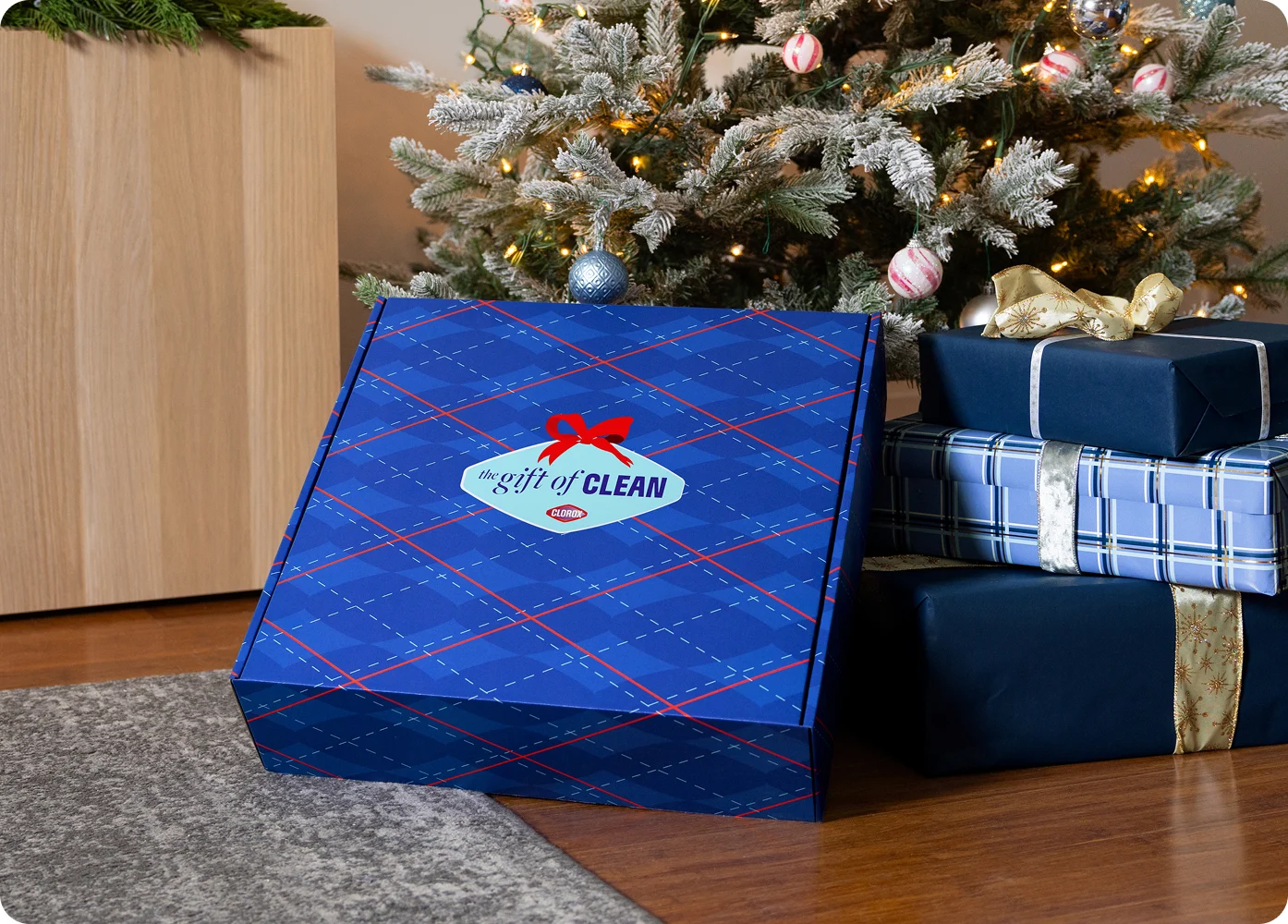Gift of Clean box under a Christmas tree with presents around it