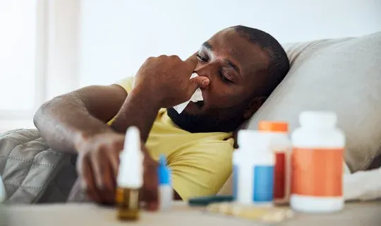 sick man in bed with medications in the foreground