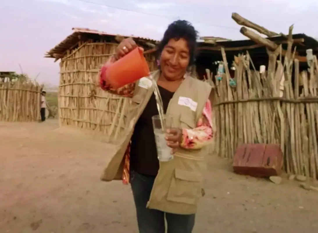 mujer vertiendo agua con una jarra en un vaso