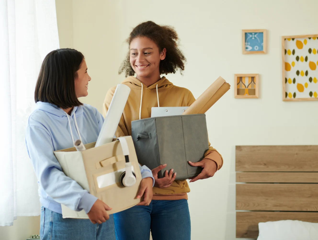 college age women carrying boxes