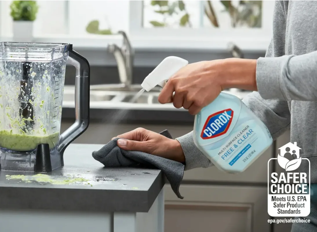 person spraying free and clear spray onto a kitchen counter