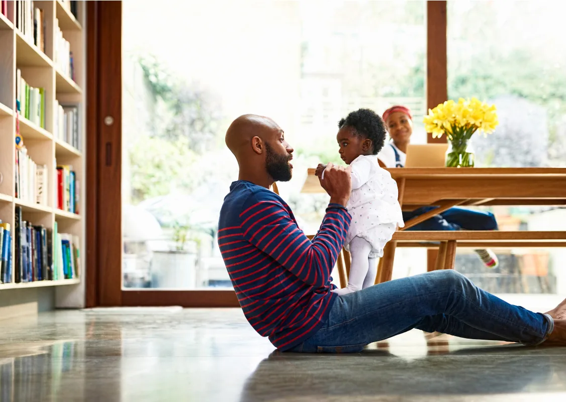 man playing with his child in the house