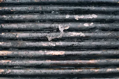 A closeup shot of a grimy grill grate showing burned residue.