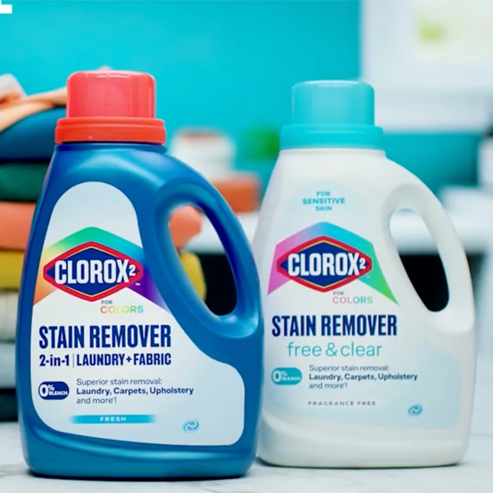 Clorox 2 Free & Clear and Laundry + Fabric stain remover bottles with laundry items.
