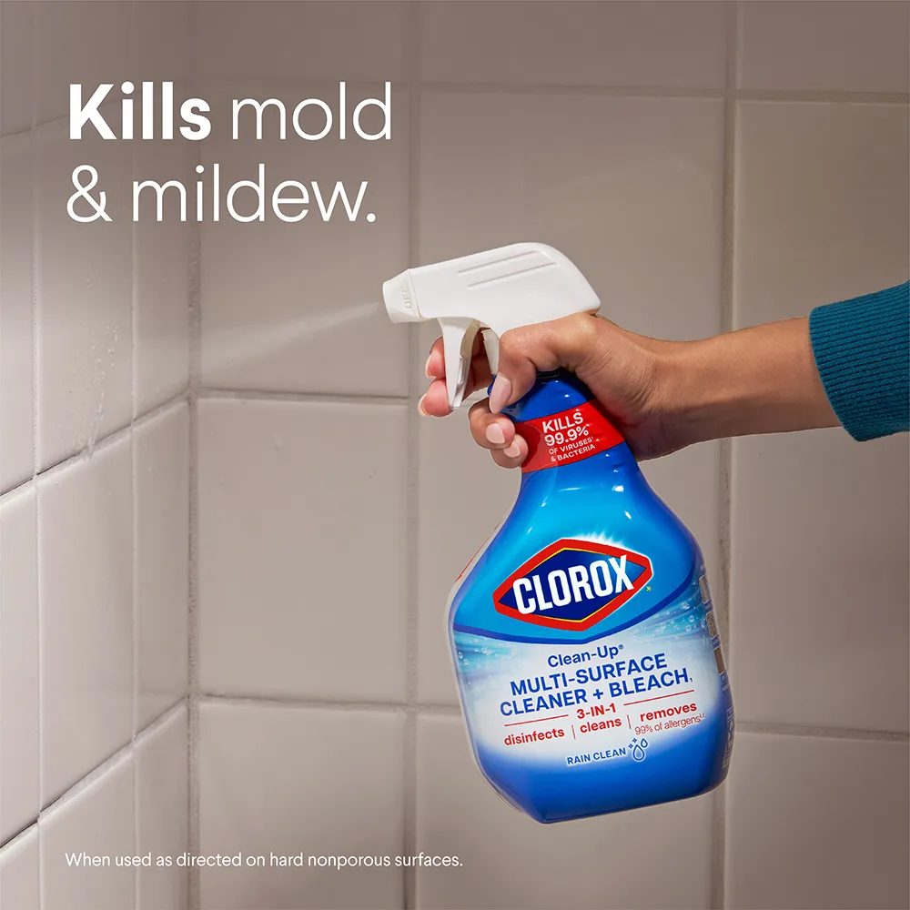 Persona rociando spray limpiador sobre los azulejos de la ducha con el mensaje "Elimina el moho y los hongos".