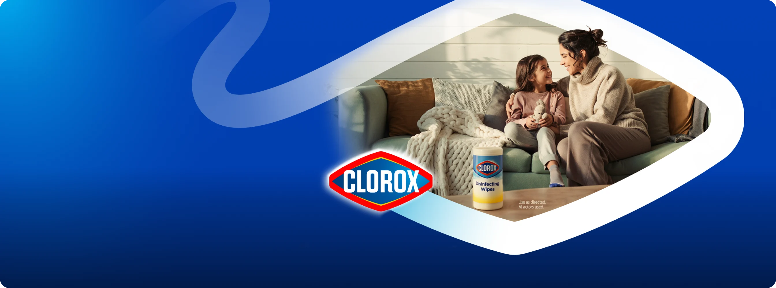 Mother and daughter relaxing on couch with Clorox Disinfecting Wipes canister on table, blue branded background.
