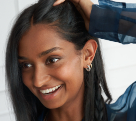 a woman with long straight hair is smiling and looking to the side