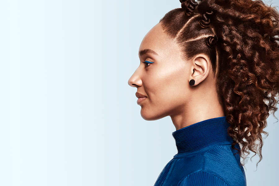 A woman with brown curly hair looks to the side