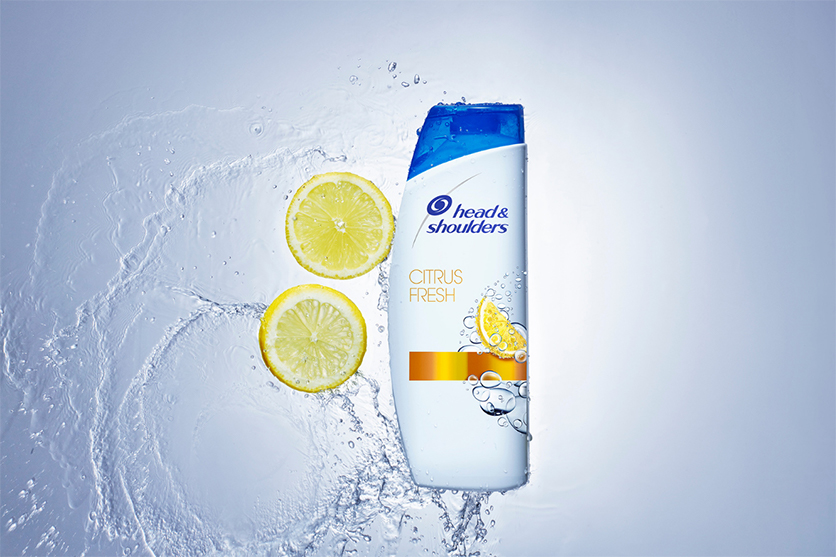 Bottle of Citrus Fresh Shampoo floating on the water, surrounded by lemons