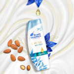 Suprême Anti-Frizz Shampoo bottle surrounded by almonds. 