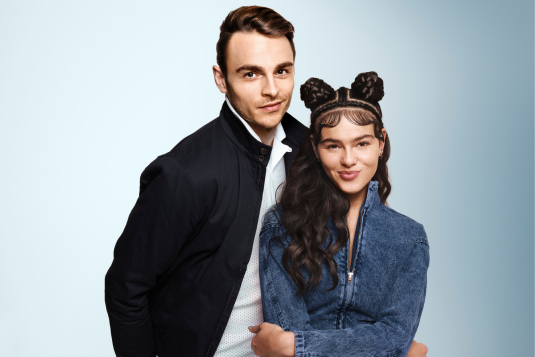 Yound man with elegant hairstyle and young woman with wavy hair and two buns.