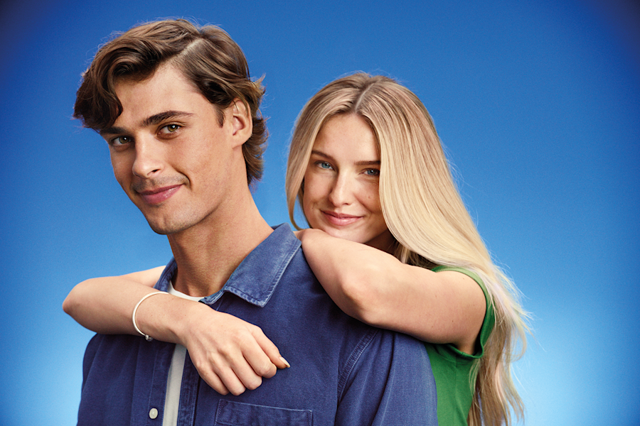 A woman with long blonde hair is embracing a man from behind.