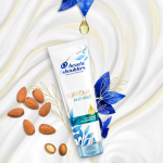 Suprême Anti-Frizz Conditioner bottle surrounded by almonds. 