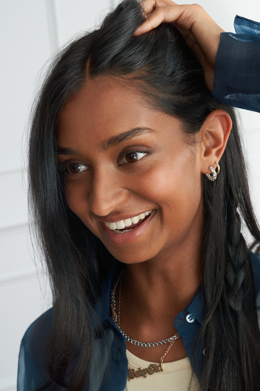 a woman with long straight hair is smiling and looking to the side