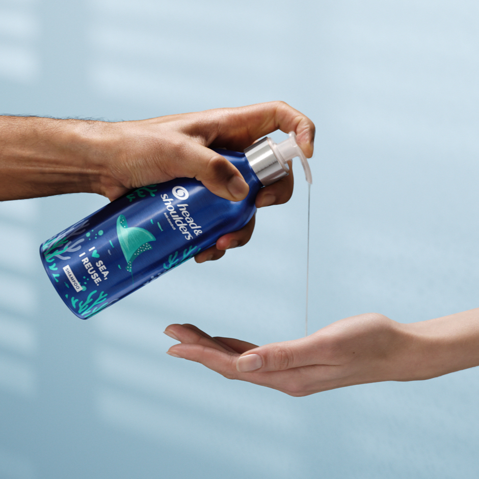 Head&Shoulders aluminium bottle - one hand pouring shampoo from the bottle on the other hand. 