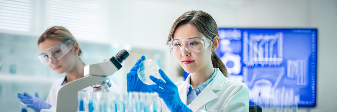 A female scientist in blue latex gloves works in a modern laboratory.
