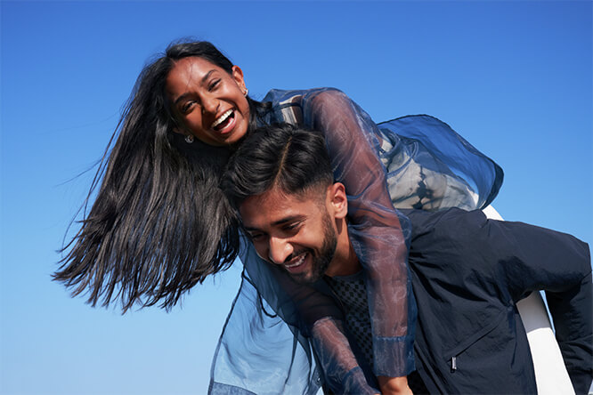 Woman on a man's back, smiling. Man holding woman on his back, smiling.
