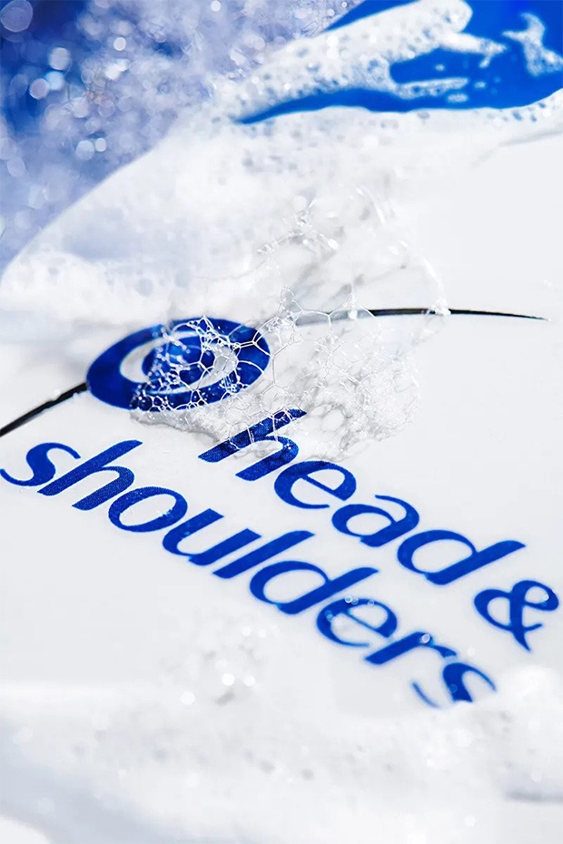 Head&Shoulders shampoo bottle with foam and bubbles on it.