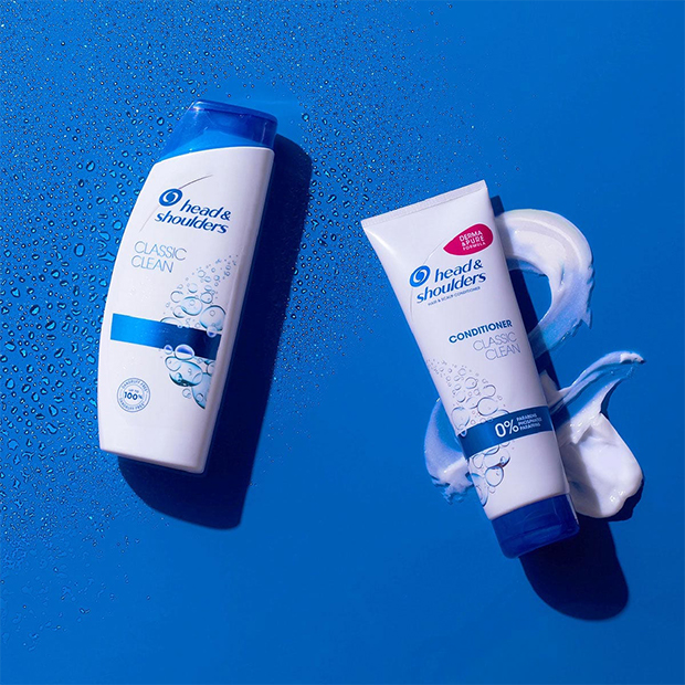 Head and Shoulders Classic Clean Antidandruff shampoo and conditioner lying on the blue background. 