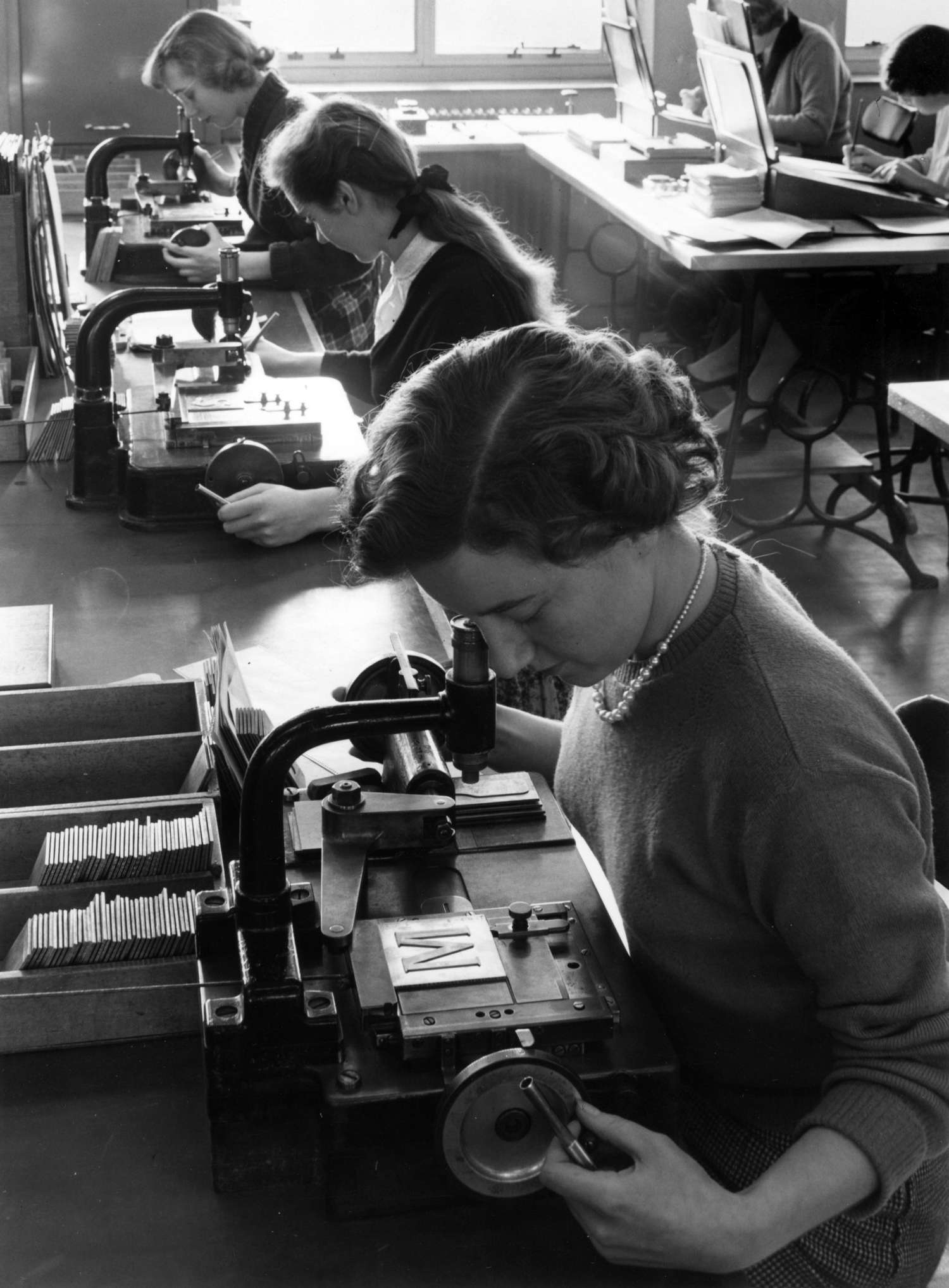 Monotype employees checking the copper patterns used for cutting punches, c. 1956. © Monotype archives