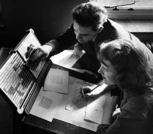Two Monotype employees working on the matrix case arrangement for a Monotype hot-metal typeface, undated. © Monotype archives
