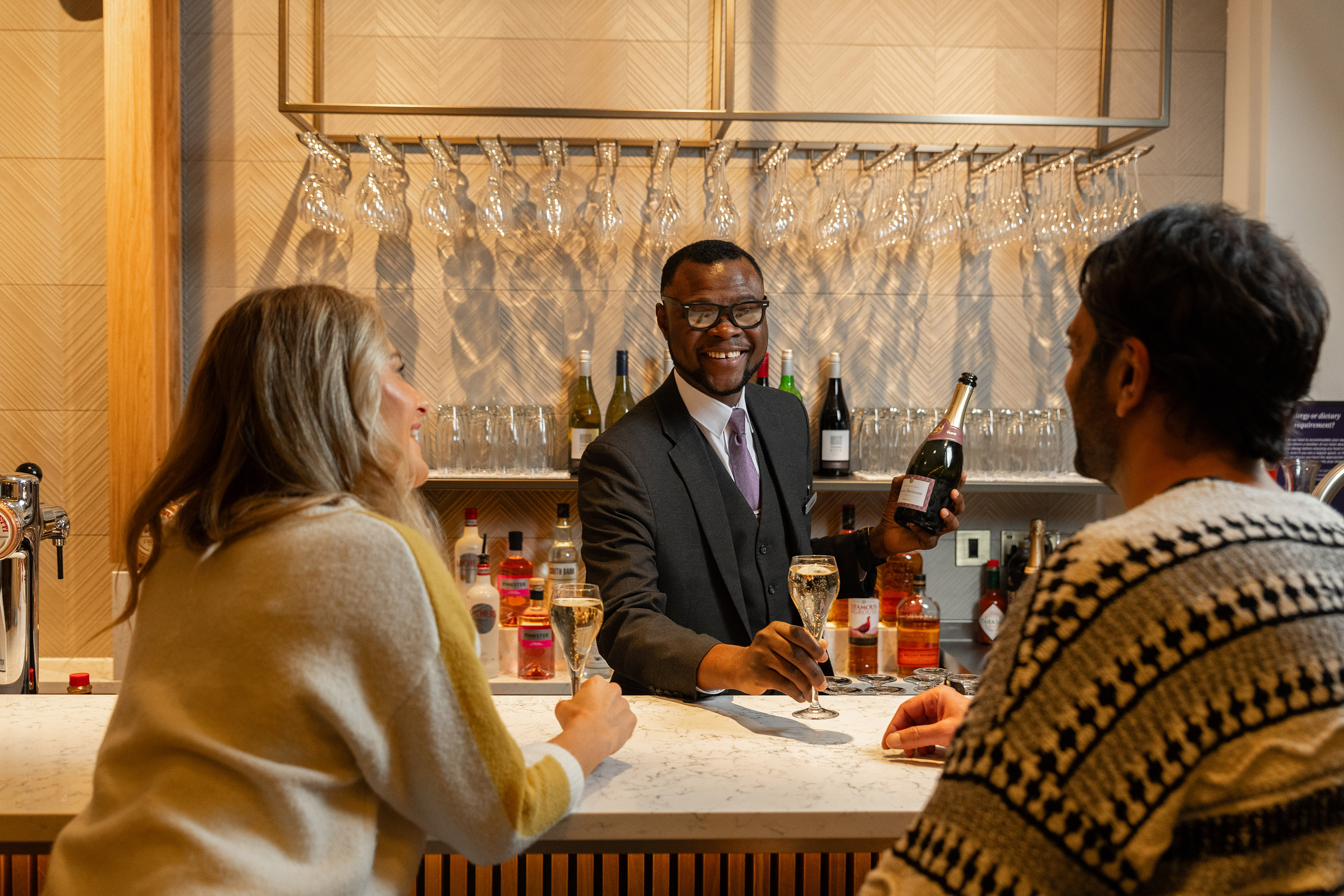 Airport lounge bar area with two guests and bartender