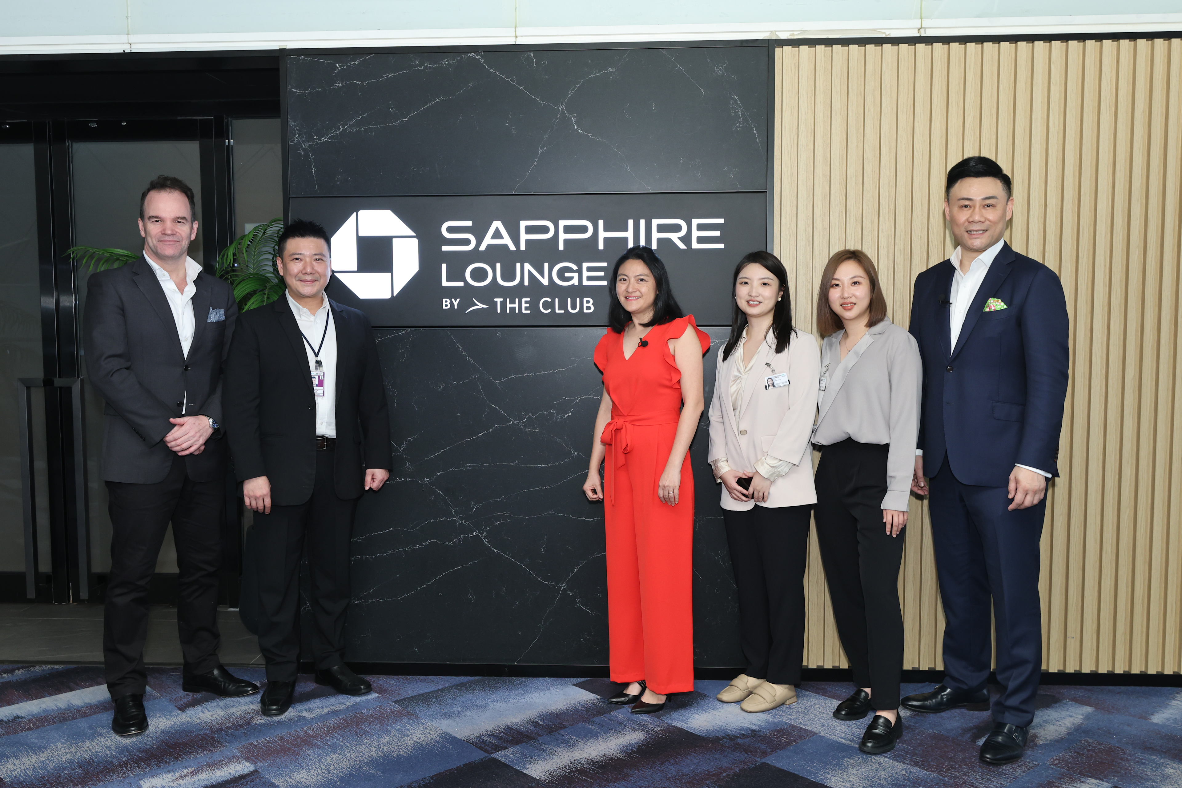 airport lounge entrance, sapphire lounge but the club, group of three women and three men standing in front 