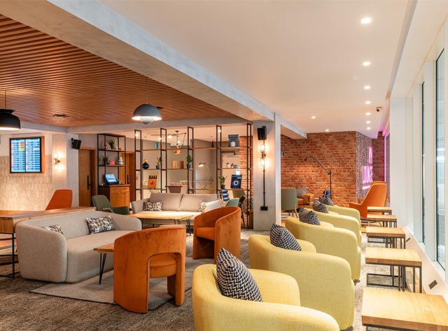 airport lounge, yellow, grey and orange sofas, windows along wall