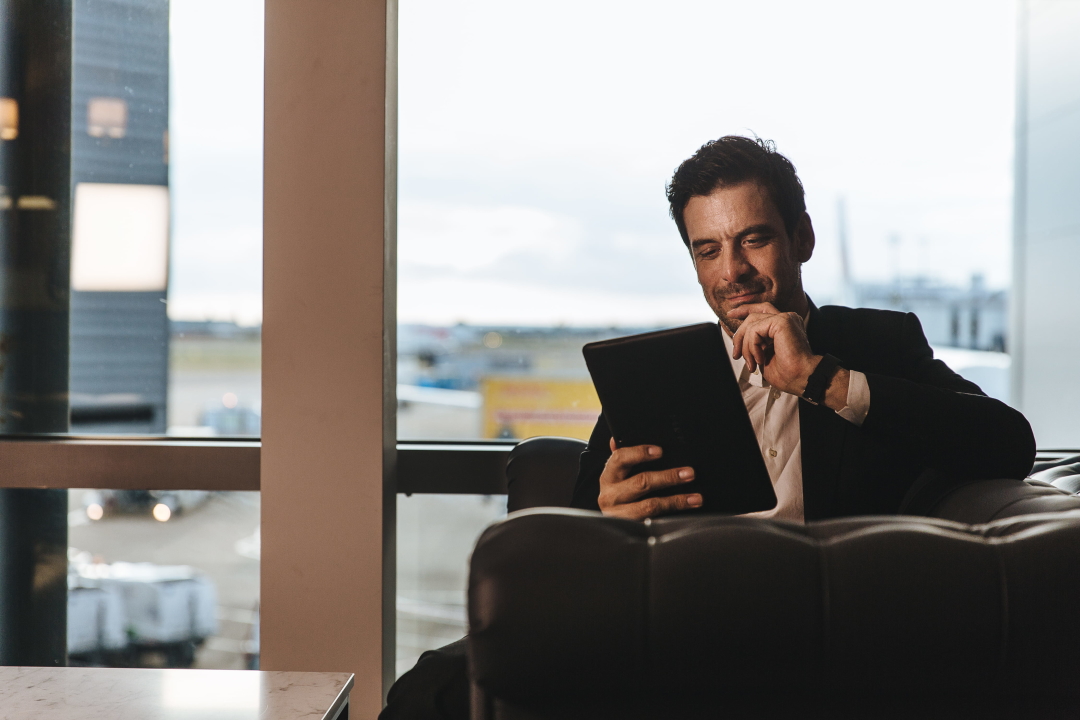 Traveler on iPad in airport lounge