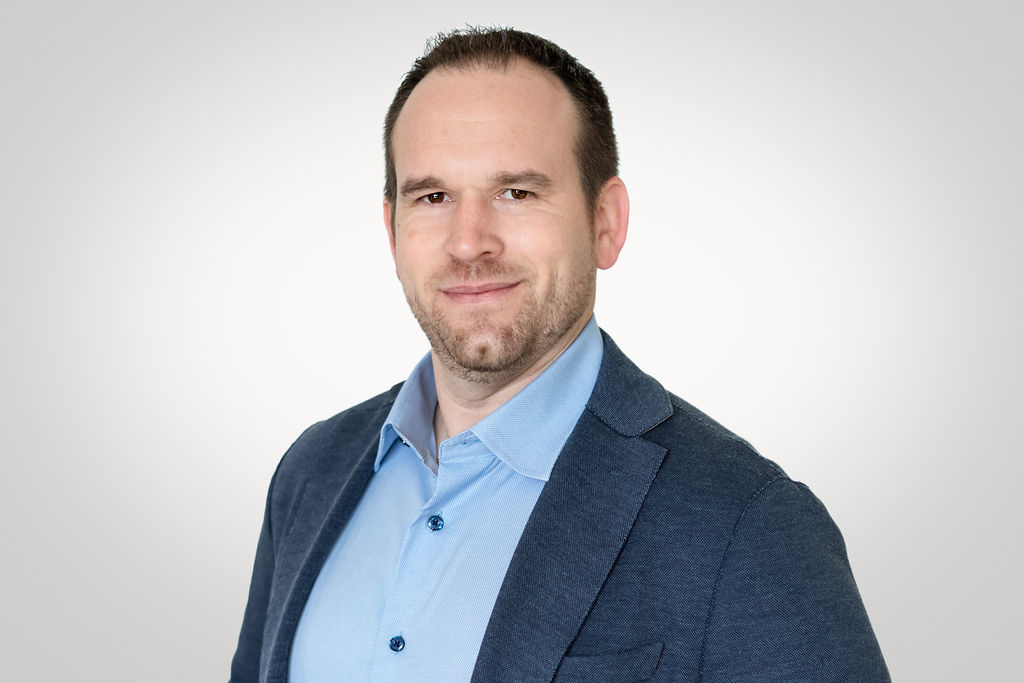 Airport Dimensions, businessman headshot in blue suit and open collar