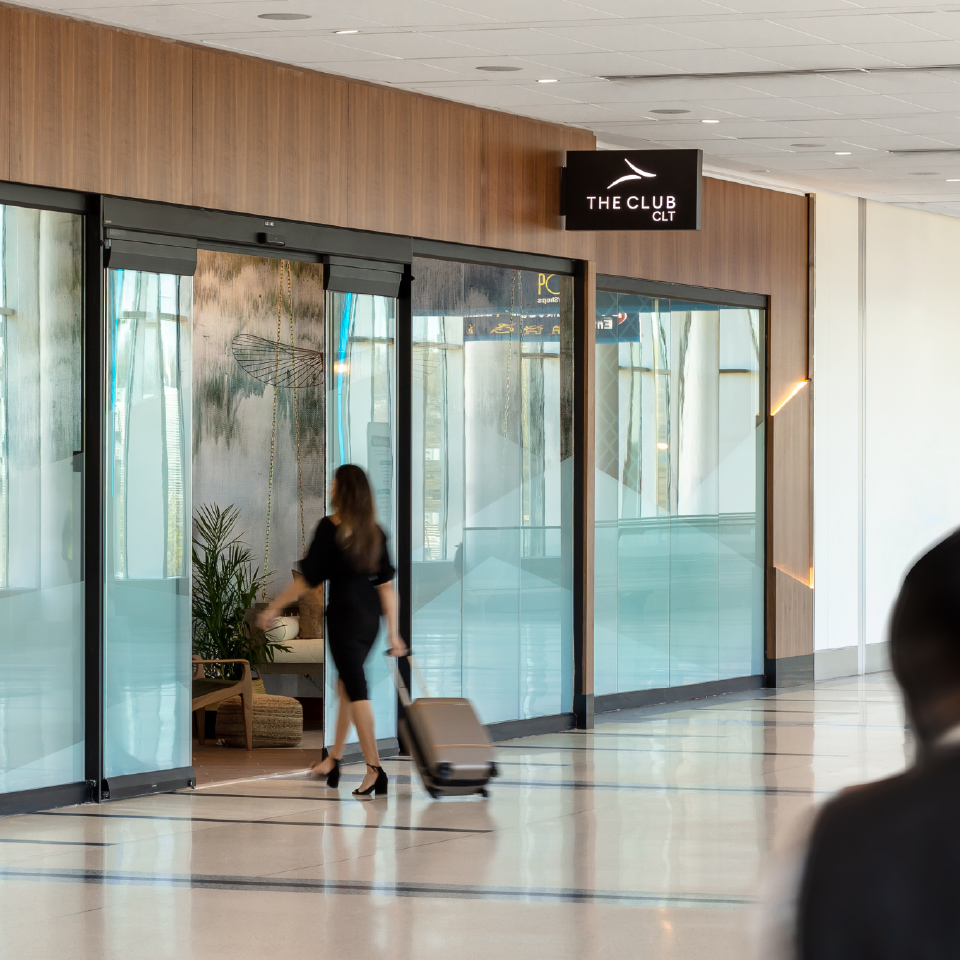 Airport Dimensions, Airport Lounges, Women walking in dress and suitcase