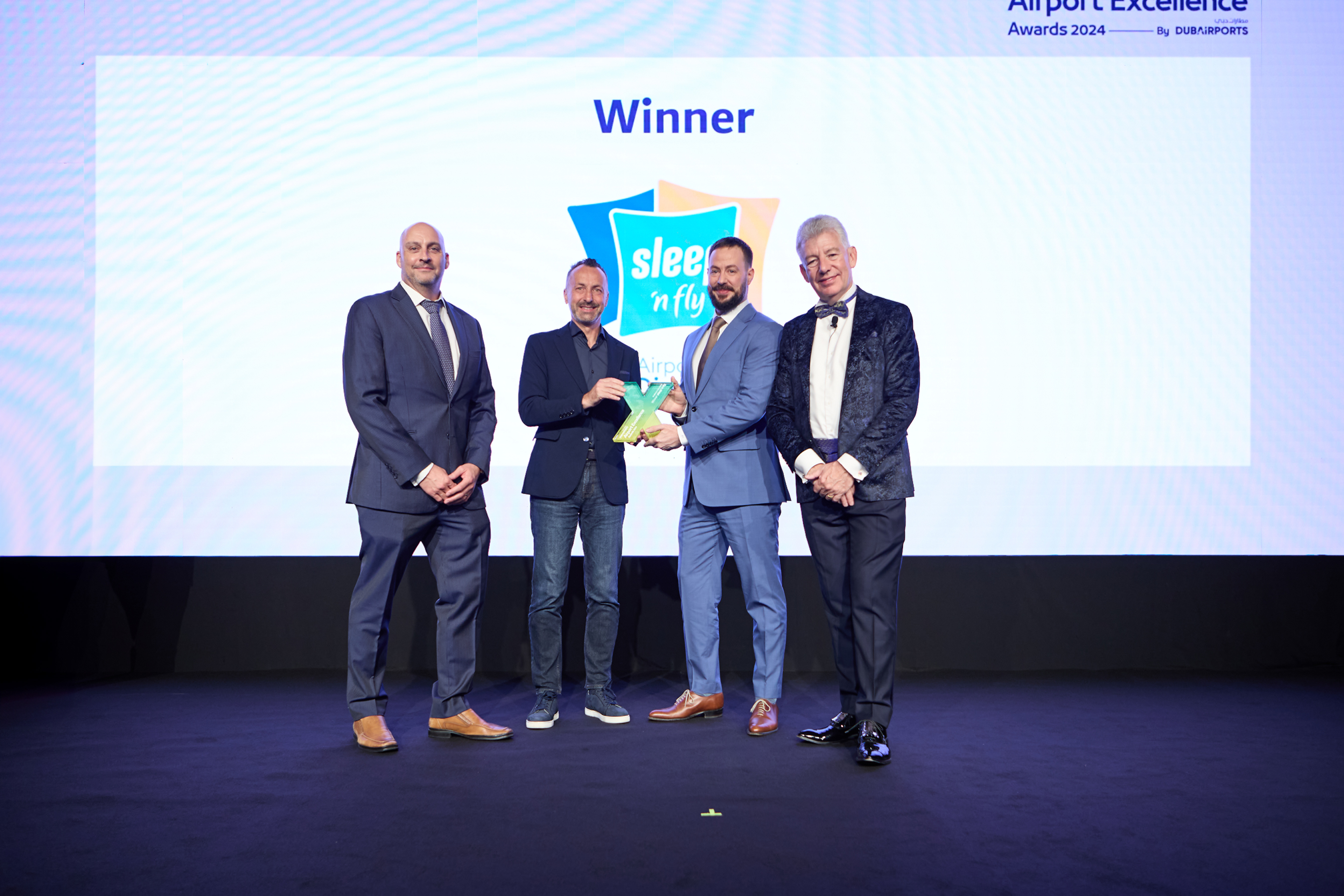 Group of men receiving award onstage 