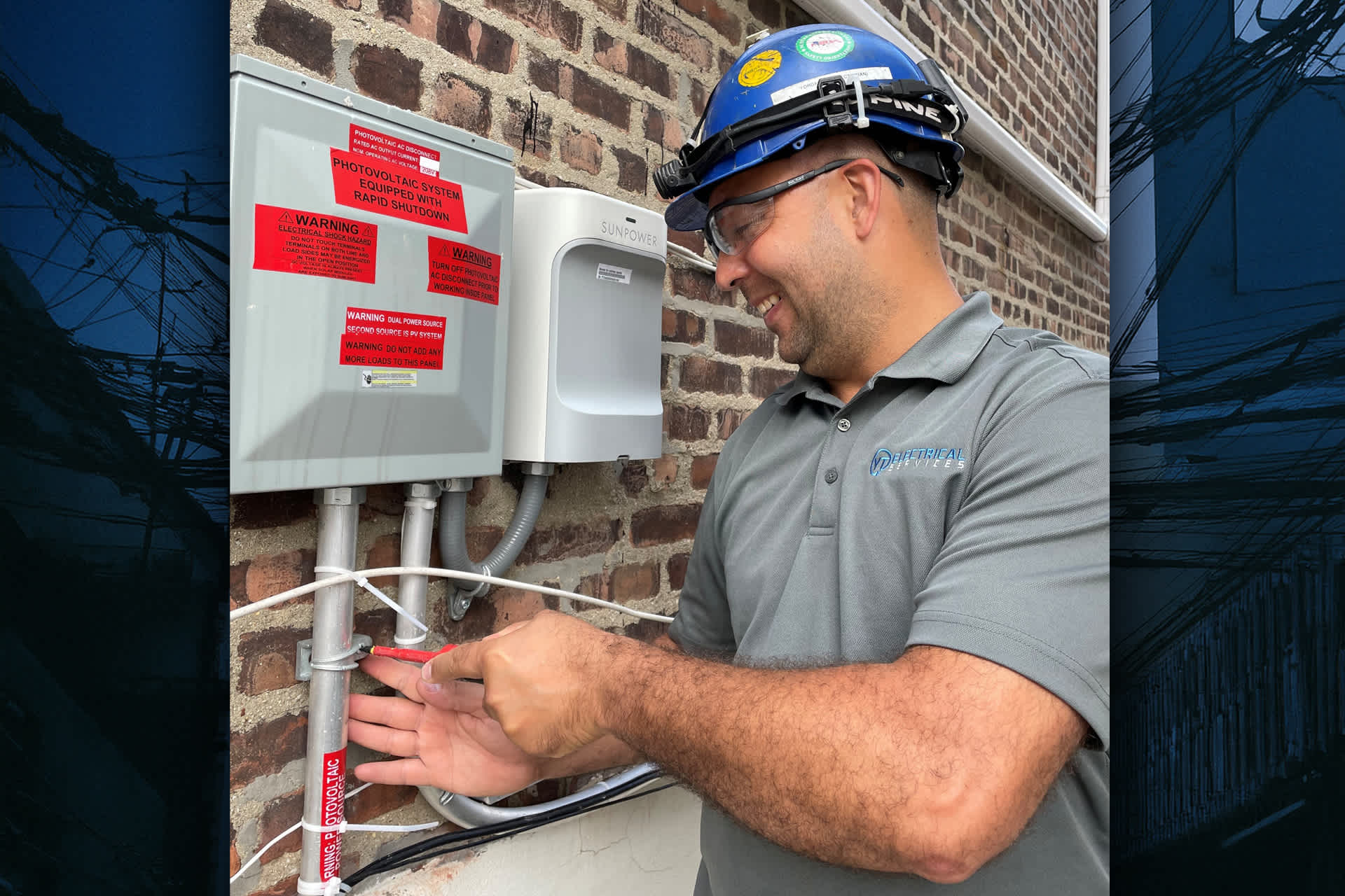 An electrician works on a solar electricity system attached to a brick wall.