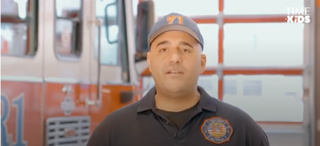 A firefighter standing in front of a fire engine