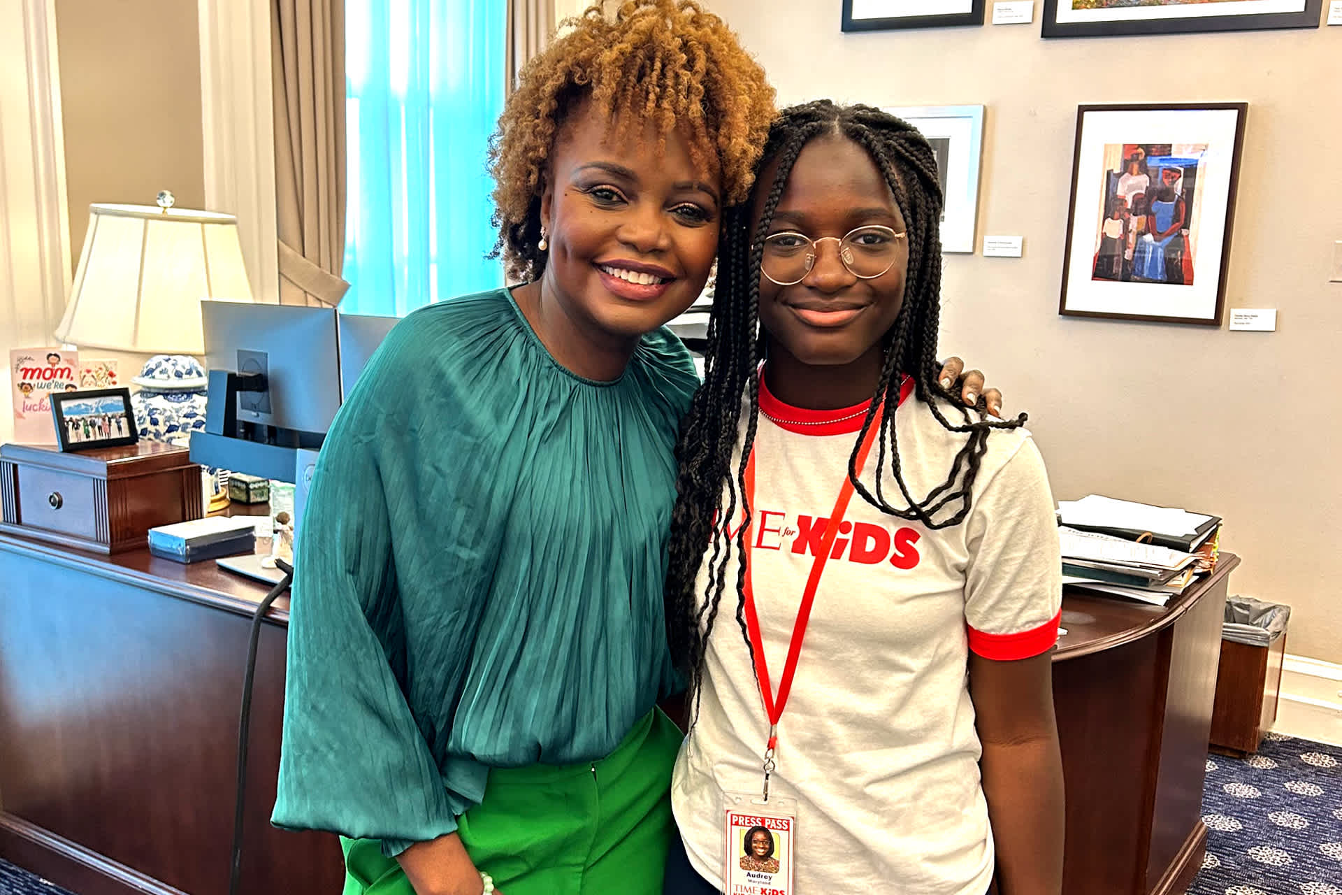 A Black woman and girl standing together in an office smiling.