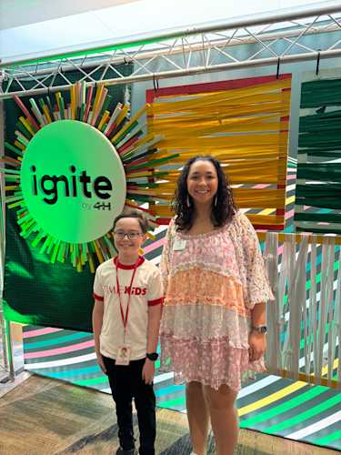 A boy and woman standing next to a display labeled, "Ignite by 4H".
