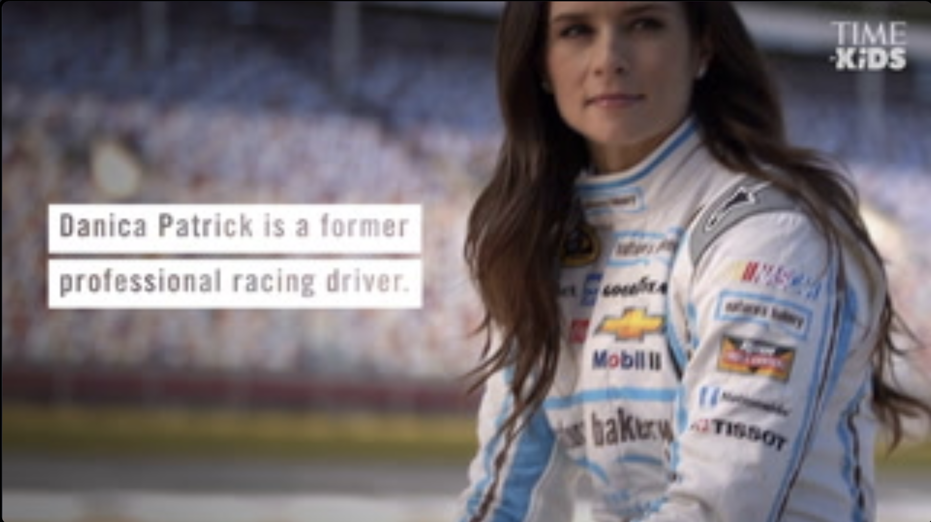 Danica Patrick seated in her racing uniform pictured from the waist up with a caption overlay that reads, "Danica Patrick is a former professional racing driver". 