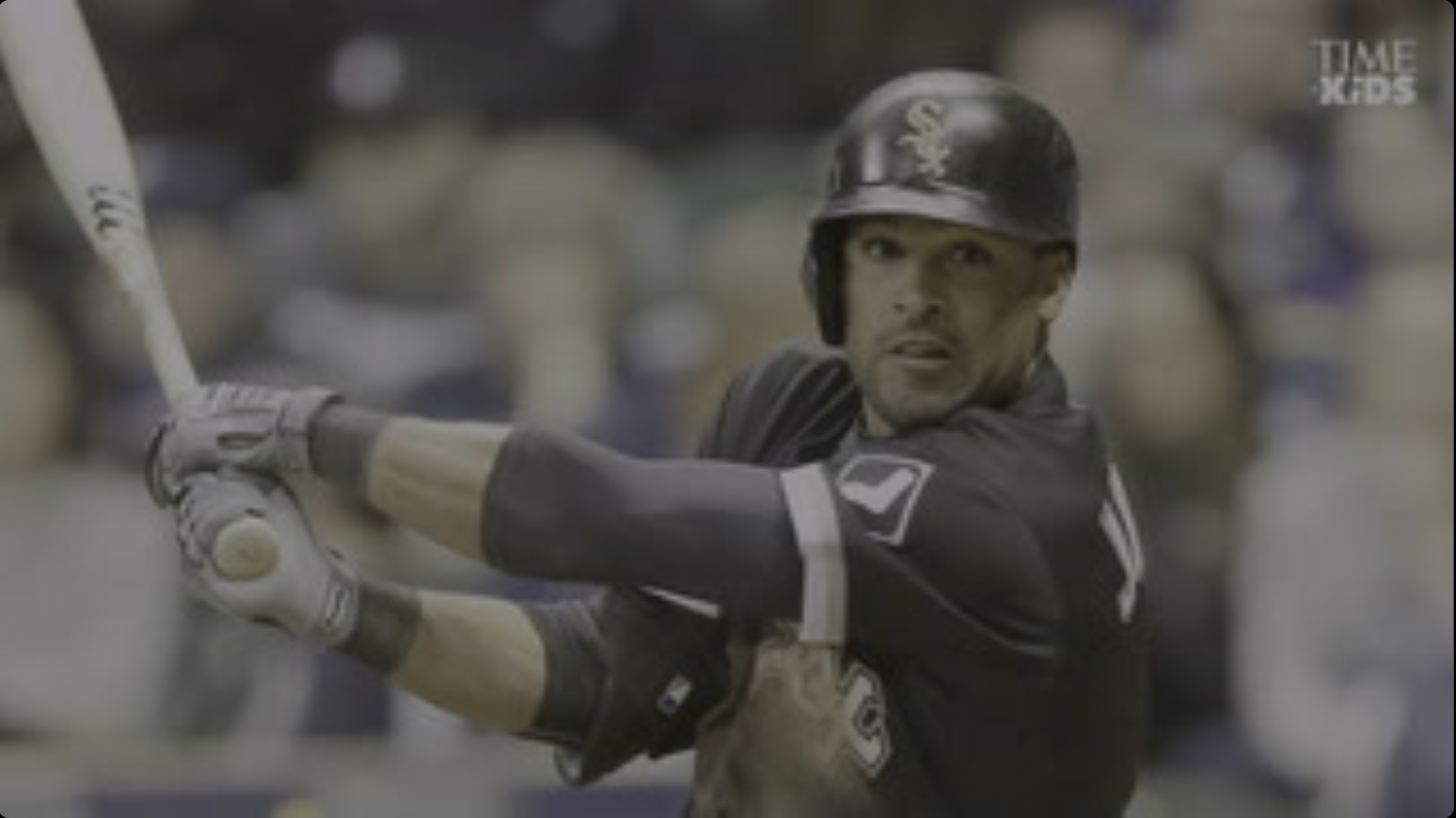 A professional baseball player has his bat cocked back ready to swing.