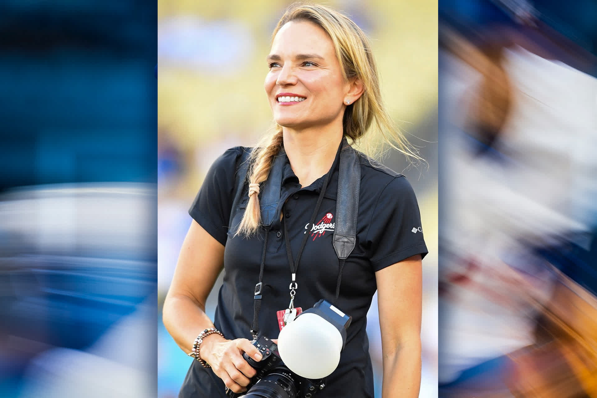 A smiling woman, holding a professional photographer's camera