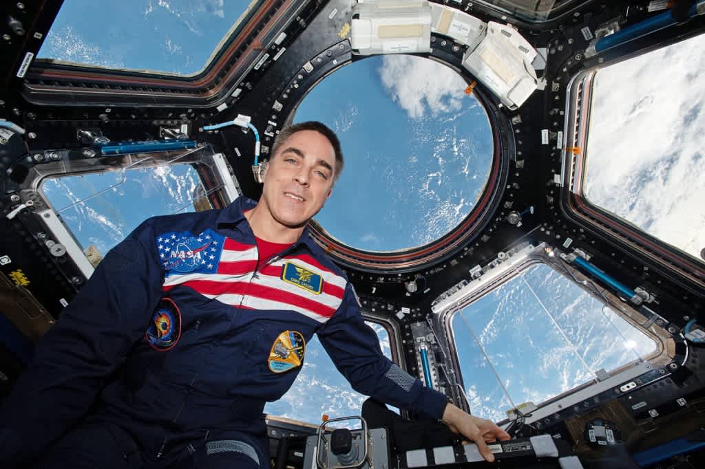 Astronaut Chris Cassidy sitting by a bay of windows on the International Space Station.