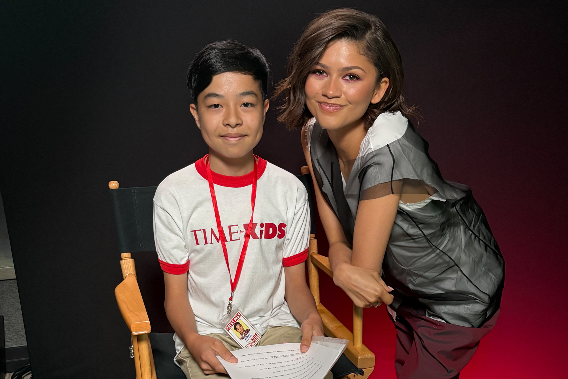 A TIME for Kids Kid Reporter sits beside an actor while holding interview questions.