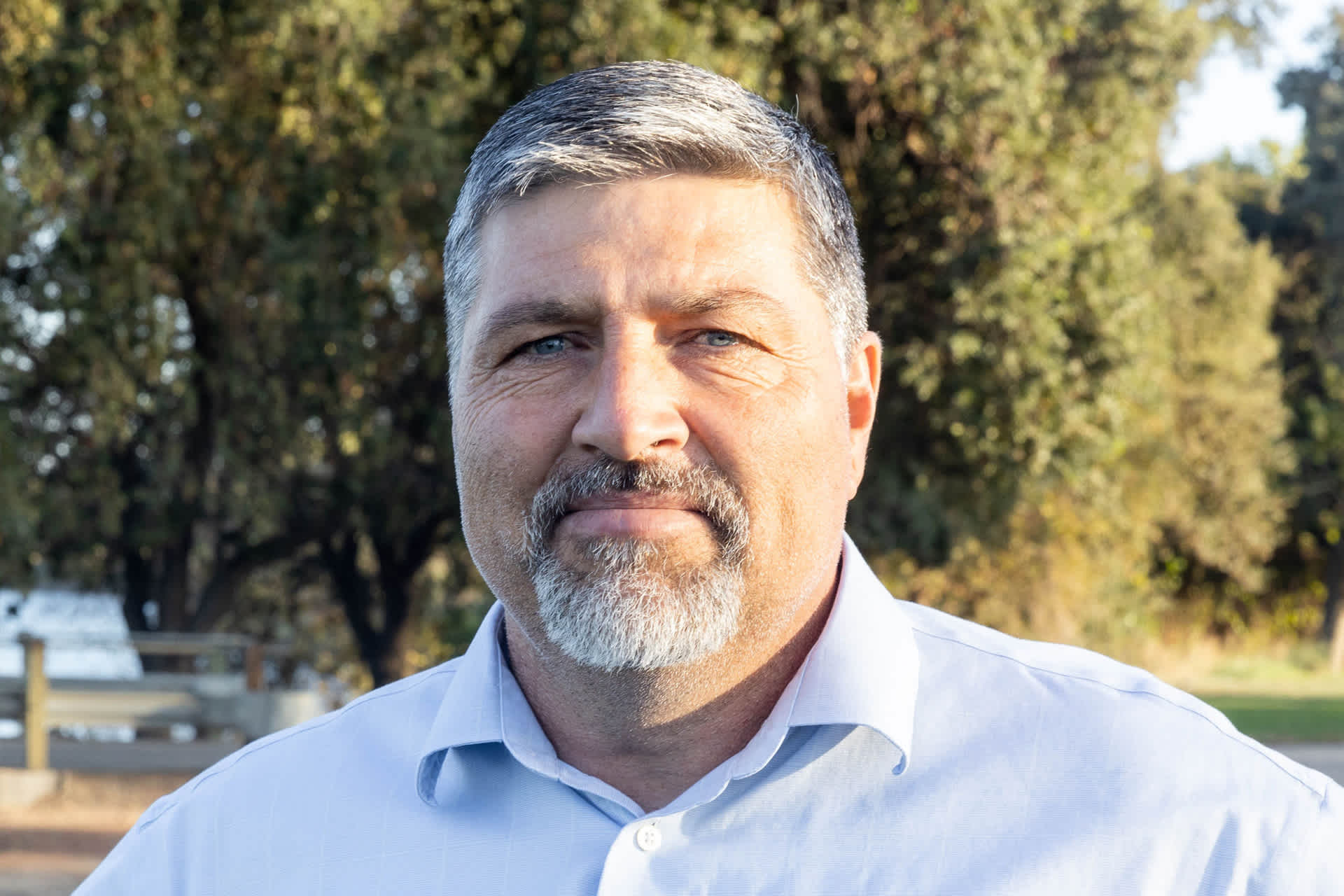 Man poses for a photo outdoors.