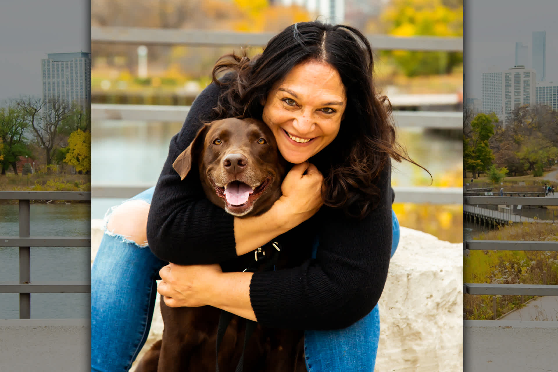 A smiling woman hugs her dog