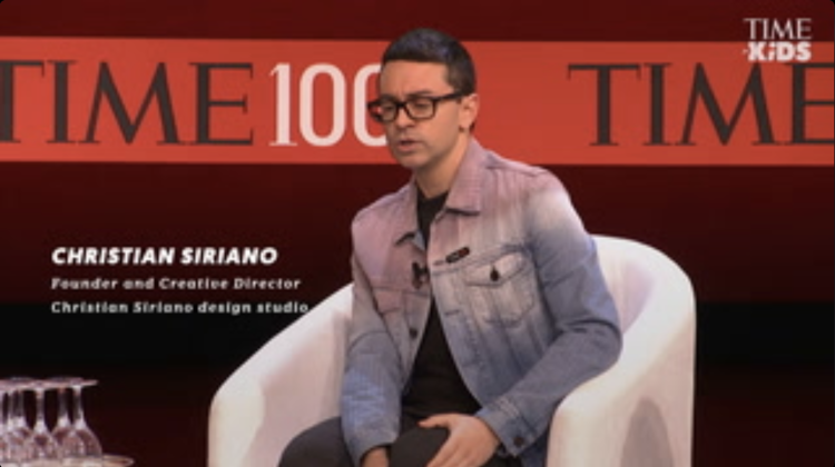 Thumbnail of a seated man, Christian Siriano, on the stage at a TIME 100 event.